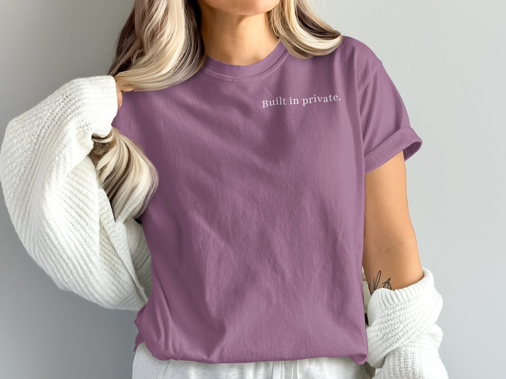 Purple t-shirt with "Built in private." text, worn with a white cardigan.